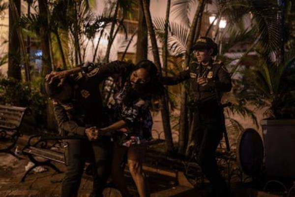 A sex worker struggles with the police after being removed from a park bench in Cartagena’s historic center on February 22.