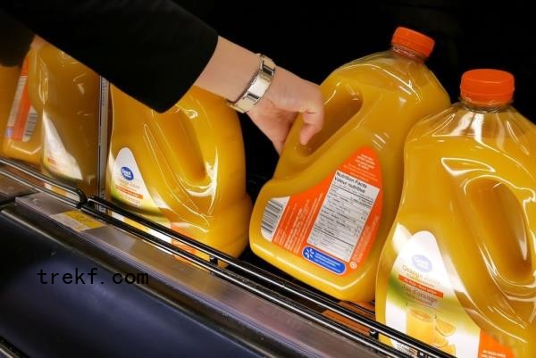 woman reaching for Great Value orange juice at Walmart