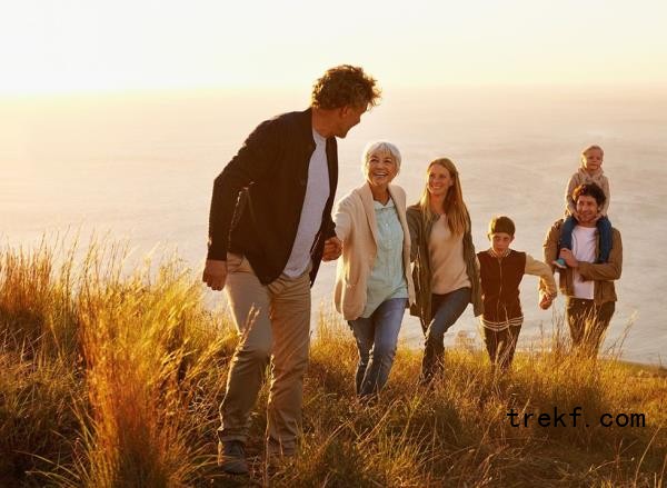 A family climbs a hill together in the sunshine