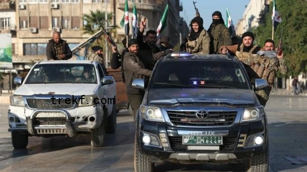 Anti-government fighters brandish their guns in Syria's northern city of Aleppo