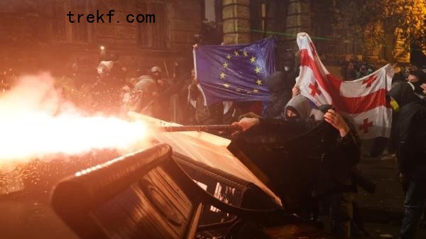 Protesters holding Georgian and European flags clash with police during a demonstration