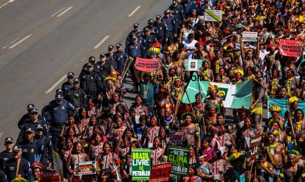 Indigenous groups protest against the marco temporal bill, which puts a cutoff date on efforts to claim new Indigenous territories. Image courtesy of Marcelo Camargo/Agência Brasil.